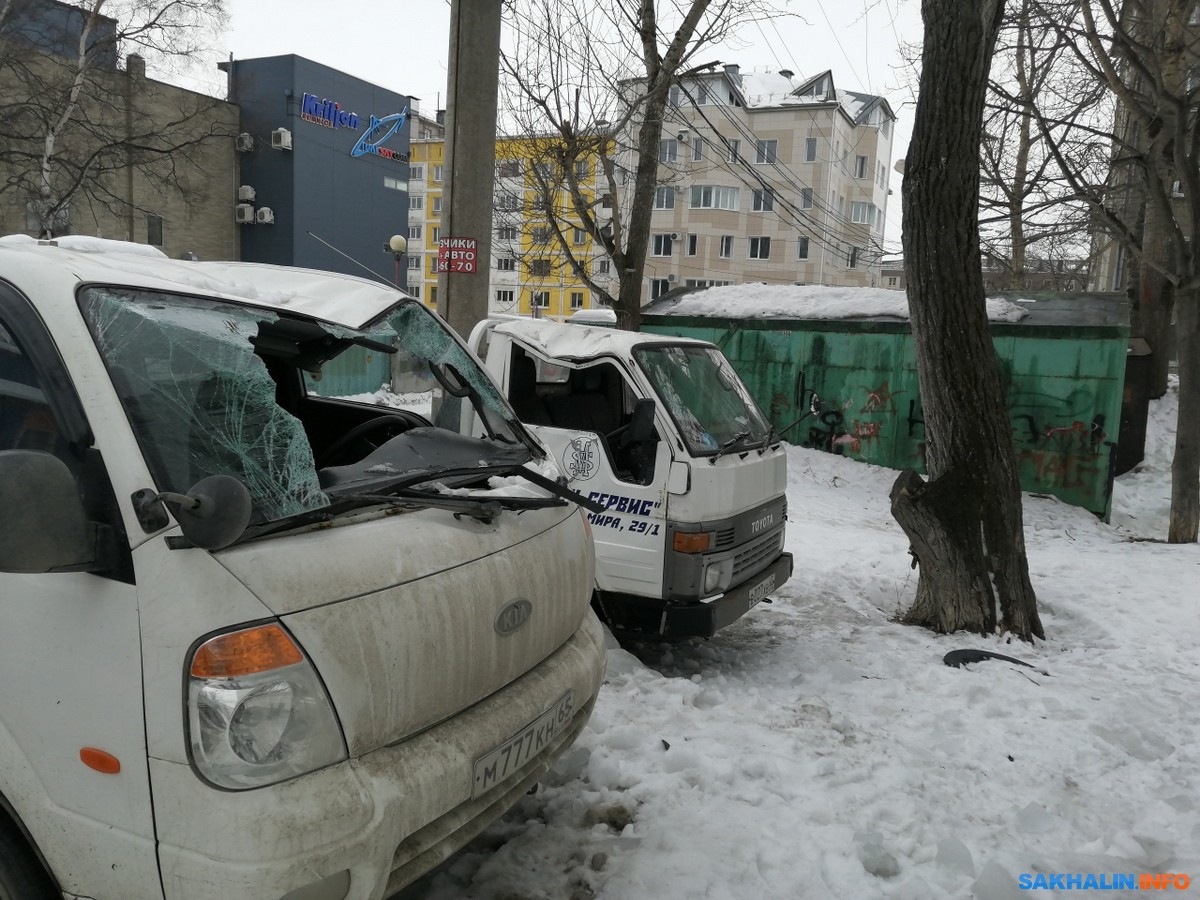 Снег с крыши дома на улице Поповича упал на два грузовика. Сахалин.Инфо